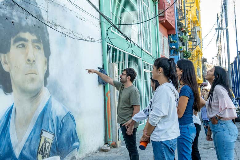 Em frente a um mural de Maradona